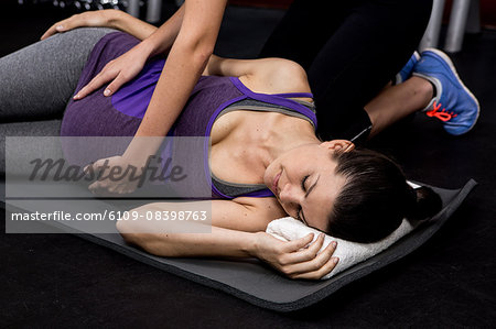 Female trainer touching pregnant womans belly