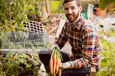 Smiling man holding carrots