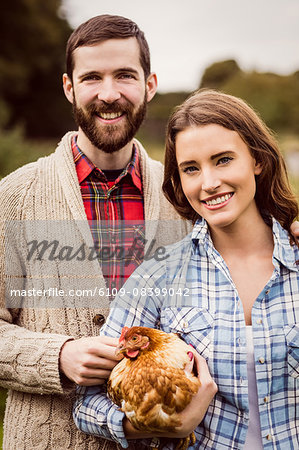 Portrait of couple holding chicken