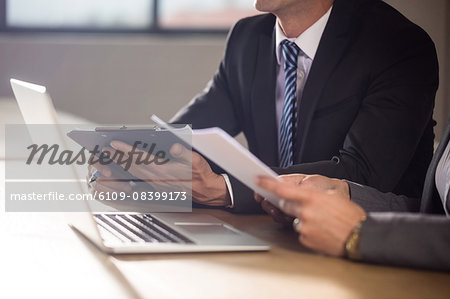 Business people working together while using laptop