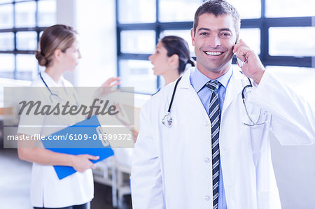 Smiling male doctor using smartphone