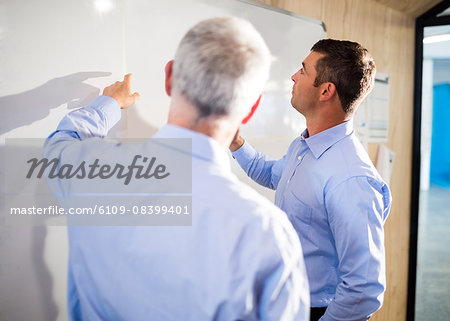 Businessmen pointing something on board