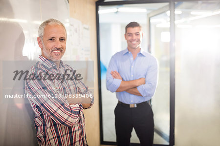 Smiling businessmen with arms crossed