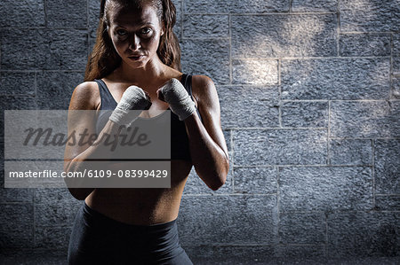 Composite image of portrait of female athlete with fighting stance
