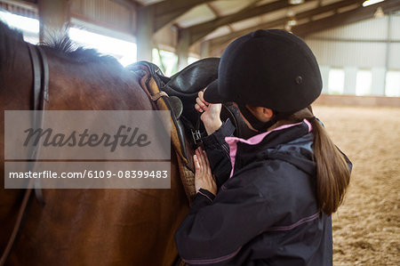 Female rider securing saddle