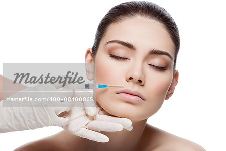 Beautiful young woman gets beauty injection in lips from sergeant. Isolated over white background.