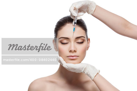 Beautiful young woman gets beauty injection in forehead from sergeant. Isolated over white background.