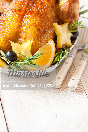 Whole roasted orange chicken with fruit garnish and rosemary for Christmas.