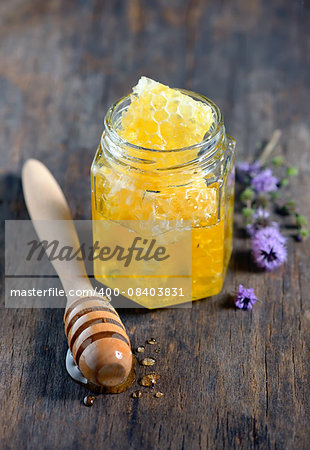 Honeycomb with Wooden Dipper on Wooden Plate