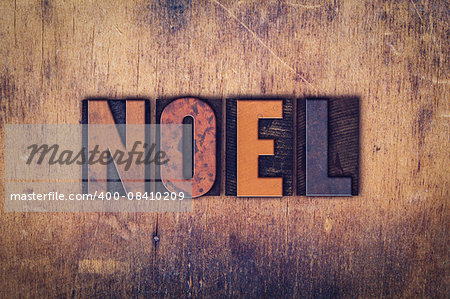 The word "Noel" written in dirty vintage letterpress type on a aged wooden background.