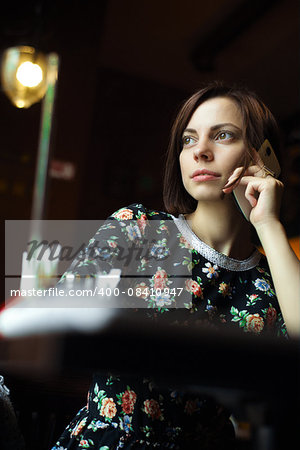 Young woman at cafe  talking on the mobile phone