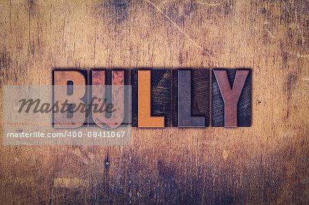 The word "Bully" written in dirty vintage letterpress type on a aged wooden background.