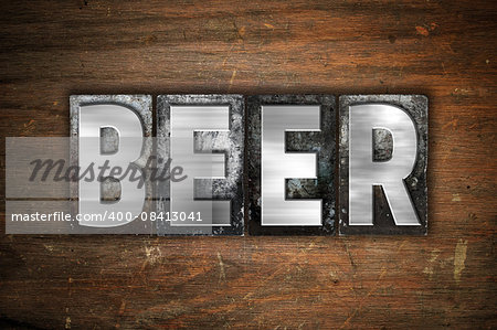 The word "Beer" written in vintage metal letterpress type on an aged wooden background.