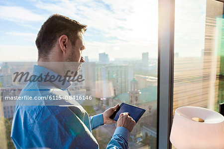 Businessman in apartment using digital tablet