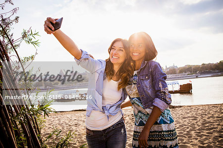 Woman and girlfriend taking a selfie with smartphone
