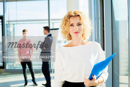 Well-dressed businesswoman with colleagues in background