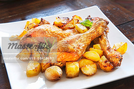 Roast chicken with potatoes, garlic and rosemary