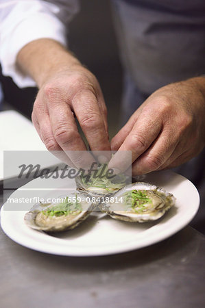 Oysters being garnished