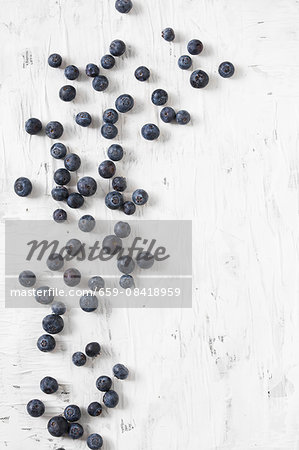 Blueberries scattered on a white surface Blueberries scattered on a white surface