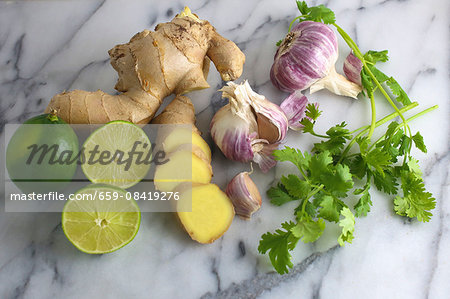 an arrangement of limes, ginger, garlic and coriander