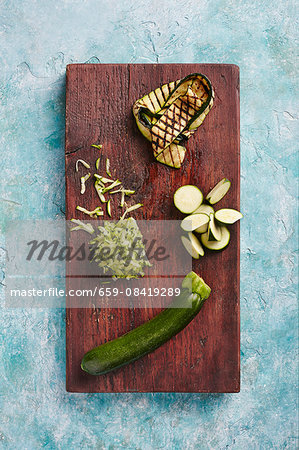 Courgette: whole, sliced, grated and grilled on a wooden board