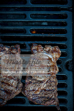 Grilled rib-eye steaks on a barbecue