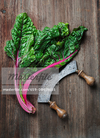 Charred and a mezzaluna knife on a wooden surface