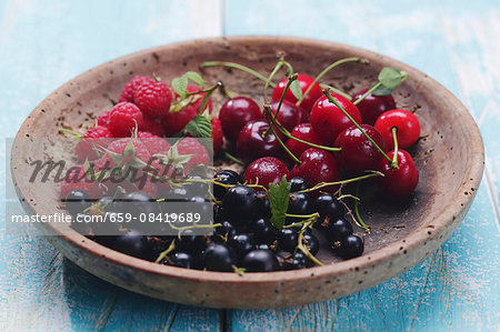 Various summer fruits in a wooden bowl