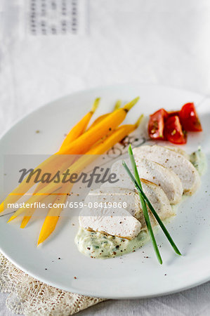 Steamed chicken breast with carrots on a creamy avocado sauce