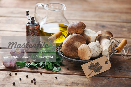 An arrangement of porcini mushrooms, oil, parsley, garlic and pepper