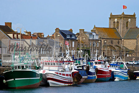 Fishing boats and harbour, and 17th century church in the background, Barfleur, one of the loveliest French village, Cotentin, Normandy, France, Europe