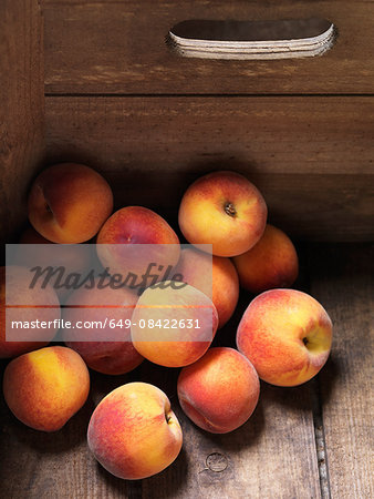 Peaches stacked in corner of wooden box