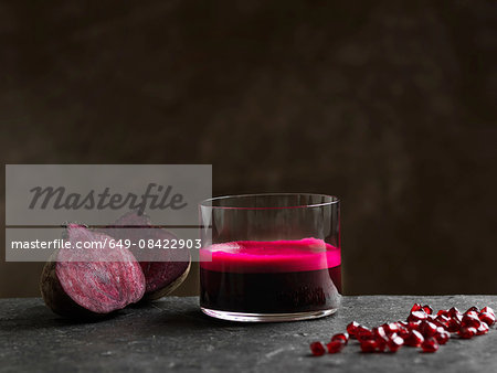 Purple raw beetroot and apple juice, halved beetroot and pomegranate seeds Purple raw beetroot and apple juice, halved beetroot and pomegranate seeds