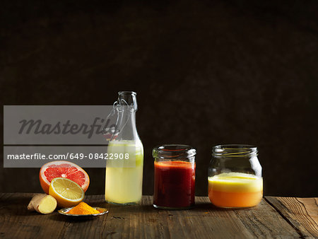 Raw juices in glass bottle and jars, dark background