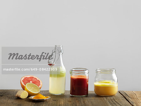 Fruit smoothies in glass bottle and jars, white background