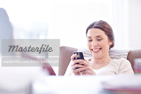 Smiling woman texting with cell phone