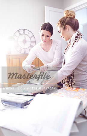 Interior designers photographing fabric swatches in office