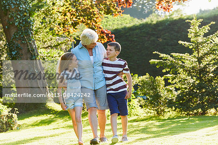 Grandmother and grandchildren walking in sunny garden