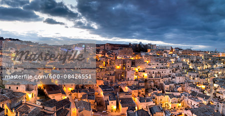 Scenic overview of congested houses of Sassi di Matera illuminated at dusk, one of the three oldest cities in the world, Matera, Basilicata, Italy