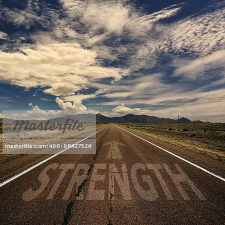 Conceptual image of desert road with the word strength and arrow