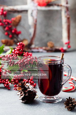 Mulled red wine with spices, orange slices on grey stone new year and Christmas background