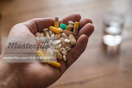 hand full of pills and vitamin supplements