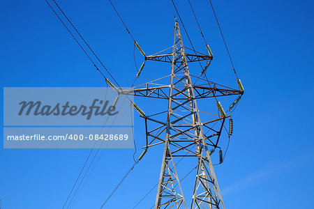 Electricity pylon on blue sky background. High voltage tower.