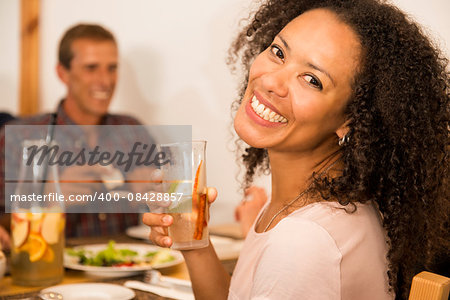 Happy Afro-American woman at the restaurant having a drink