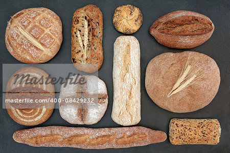 Rustic homemade bread selection on slate background.