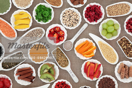 Super food collection in porcelain bowls, spoons and scoops over black background. High in vitamins and antioxidants.