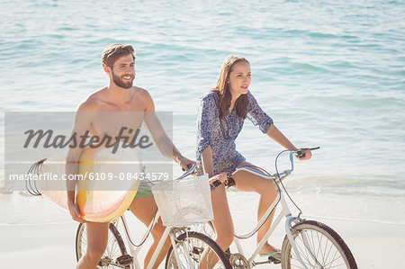 Happy couple going on a bike ride at the beach