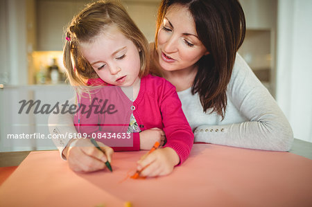 Mother and daughter drawing together at home