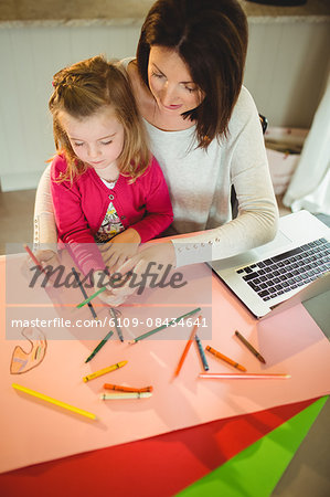 Mother and daughter drawing together at home