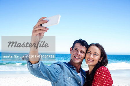 Cute couple taking a selfie on the beach
